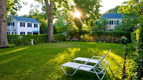 a white chair sitting in the yard of a house at Captain Morse House - Luxury, Waterfront, Town, & Beaches - 5 stars in Edgartown