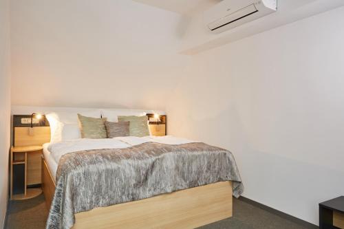 a bedroom with a bed in a white room at Gold House Pension in Balatonfüred