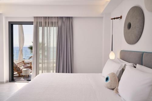 a bedroom with a white bed with a view of the ocean at Icon Suites in Potos