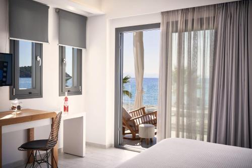 a hotel room with a bedroom with a view of the ocean at Icon Suites in Potos