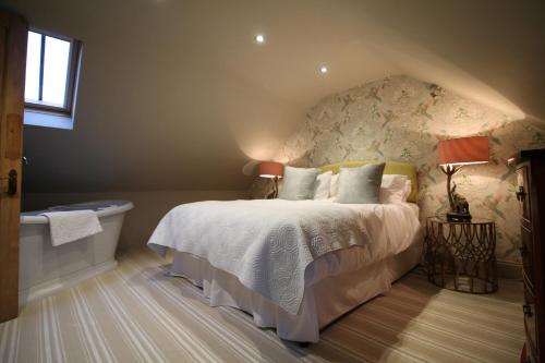 a bedroom with a bed and a bath tub at Drake Cottage in Whitby