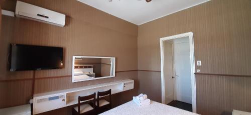 a hotel room with a mirror and a bed at Hotel Rivadavia in Piriápolis