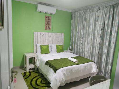 a green bedroom with a bed and a green wall at The Zion Hill in East London