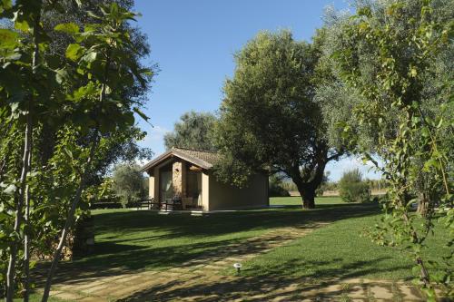 a cottage in the middle of a field with trees at Inghirios Wellness Country Resort in Santa Maria la Palma