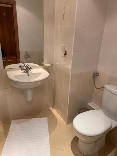 a bathroom with a white toilet and a sink at Studios -Villa Park SV in Borovets