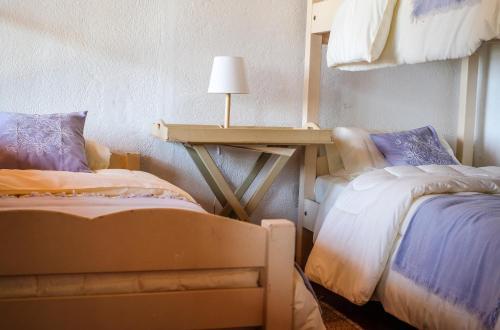 1 dormitorio con 2 camas y mesa con lámpara en Hacienda Bellavista, en Villa Alemana