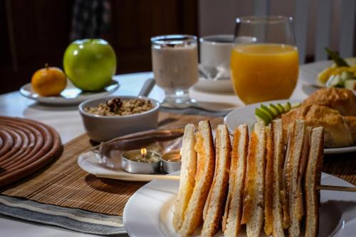 a table topped with plates of food and orange juice at Hacienda Bellavista in Villa Alemana