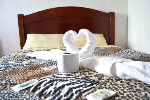 two swans are sitting on a bed with towels at Quilotoa Green Lake in Quilotoa