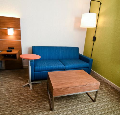a living room with a blue couch and a table at Holiday Inn Express Hotel & Suites Port Clinton-Catawba Island by IHG in Port Clinton