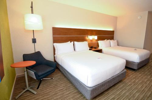 a hotel room with two beds and a chair at Holiday Inn Express Hotel & Suites Port Clinton-Catawba Island by IHG in Port Clinton