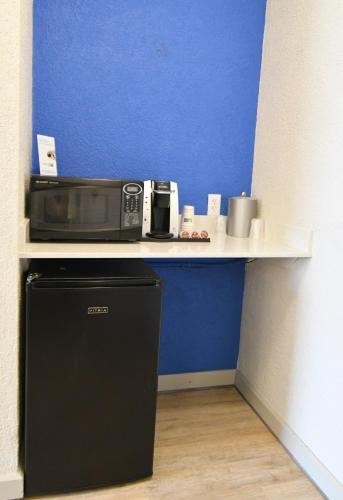 a microwave sitting on a counter next to a refrigerator at Holiday Inn Express Hotel & Suites Port Clinton-Catawba Island by IHG in Port Clinton