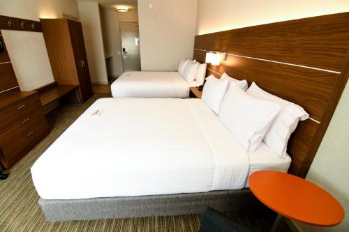 a hotel room with two beds and a table at Holiday Inn Express Hotel & Suites Port Clinton-Catawba Island by IHG in Port Clinton