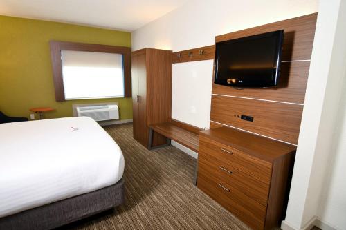a hotel room with a bed and a flat screen tv at Holiday Inn Express Hotel & Suites Port Clinton-Catawba Island by IHG in Port Clinton