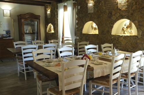 a dining room with a long table and white chairs at Inghirios Wellness Country Resort in Santa Maria la Palma