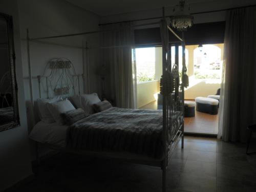 Baños y MendigoにあるVilla Titaのベッドルーム1室(ベッド1台、ソファ、窓付)