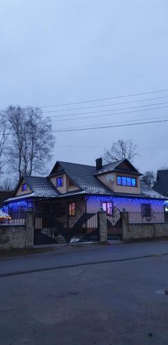 een huis met blauwe lichten aan de voorkant bij Mlynski in Mykulychyn