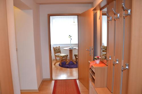 a hallway with a door open to a room with a table at Hotel Vierenstraße in Neudorf