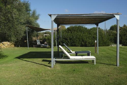 avisor with two lounge chairs in a yard at Inghirios Wellness Country Resort in Santa Maria la Palma