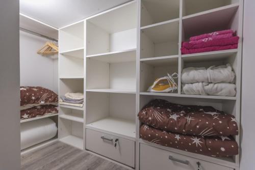 a walk in closet with white cabinets and shelves at Nina in Banja Koviljača