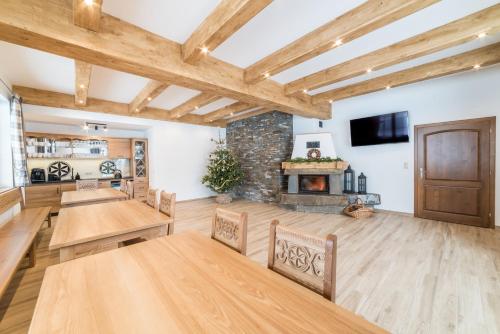 a large living room with wooden tables and a fireplace at Apartamenty Augustynówka in Brzegi