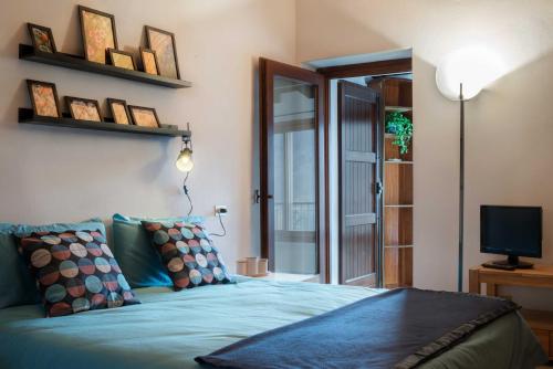 - une chambre avec un lit bleu et une télévision dans l'établissement Hiking Escape Parzanica, à Parzanica
