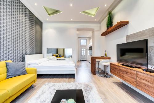 - un salon avec un canapé jaune et une télévision dans l'établissement Diamond Residence - Marble Apartment, à Budapest