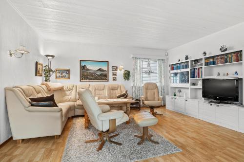 a living room with a couch and a tv at Villa Reinebringen in Reine
