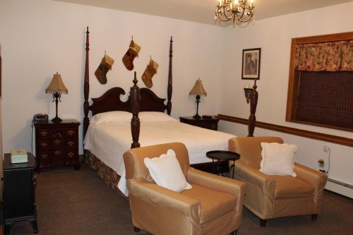 a bedroom with a large bed and two chairs at Maria's Creekside B&B in Anchorage