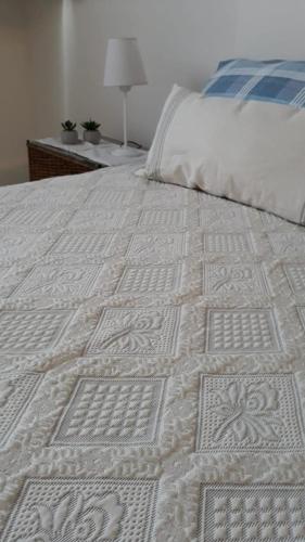 uma grande cama branca com um edredão branco em relajado monoambiente em San Miguel de Tucumán