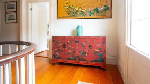 a red cabinet in a room with a painting on the wall at Captain Morse House - Luxury, Waterfront, Town, & Beaches - 5 stars in Edgartown