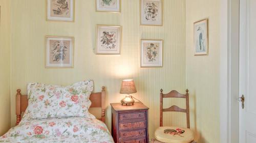 a bedroom with a bed and a lamp and a chair at Captain Morse House - Luxury, Waterfront, Town, & Beaches - 5 stars in Edgartown