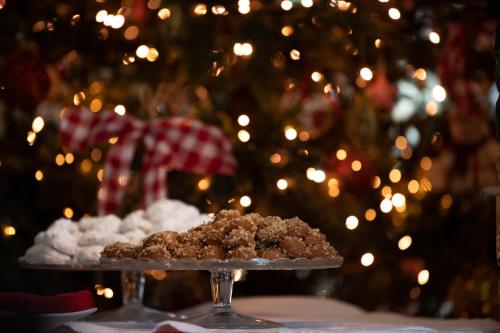 a plate of food on a table in front of a christmas tree at Erofili Hotel & Suites in Portaria