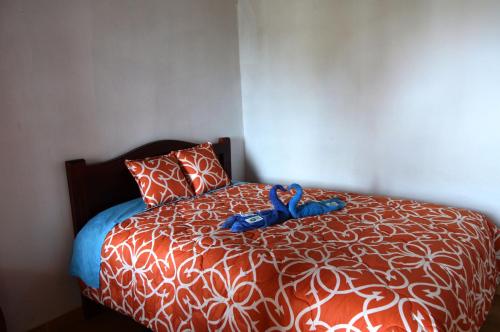 a bedroom with a bed with a red and white comforter at Quilotoa Green Lake in Quilotoa