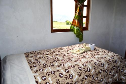 a bedroom with a bed with a cup and a window at Quilotoa Green Lake in Quilotoa