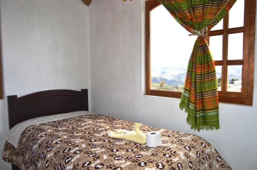 a bedroom with a bed with a window and a candle at Quilotoa Green Lake in Quilotoa