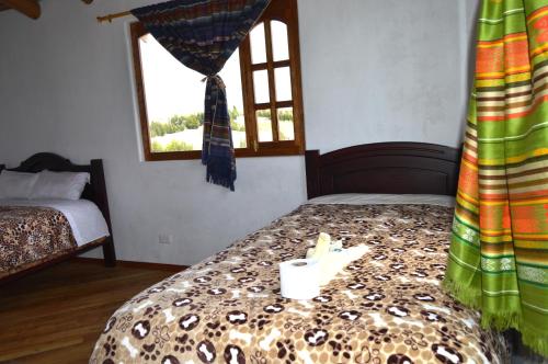 a bedroom with a bed and a window at Quilotoa Green Lake in Quilotoa