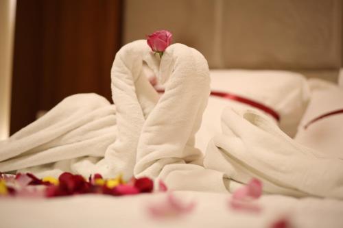 a rose sitting in a towel on a bed at ريف قباء للشقق الفندقيه in Al Madinah