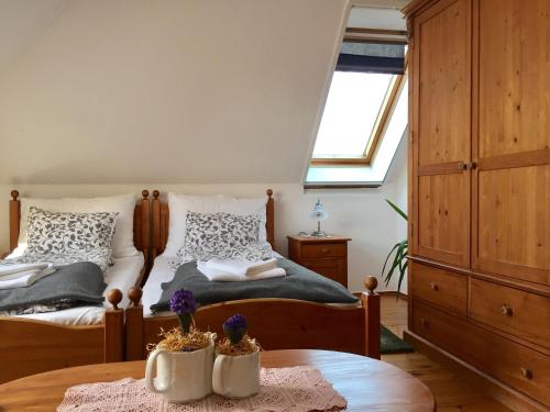 um quarto com 2 camas e uma mesa em Ámbitus-ház em Egerszalók