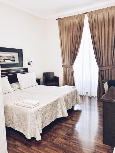 a bedroom with a large bed and two large windows at Hostal Mayor in Madrid