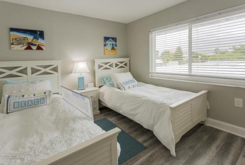 a bedroom with two beds and a window at Waterfront & Pool Star5Vacations in St. Pete Beach