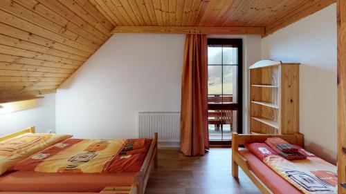 a bedroom with two beds and a wooden ceiling at Apartmány Ester in Rokytnice nad Jizerou
