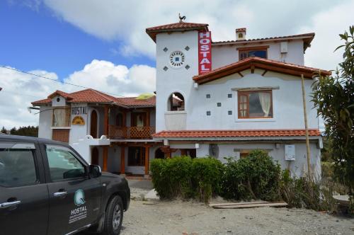 a car parked in front of a building with a clock tower at Quilotoa Green Lake in Quilotoa