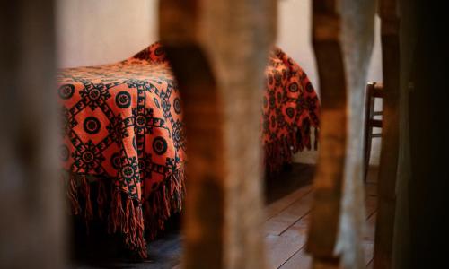 a bedroom with a bed with a red and black blanket at Alle Vecchie Querce in Fontecchio