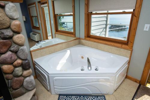 a bath room with a tub and a sink at Quarterdeck Resort in Nisswa