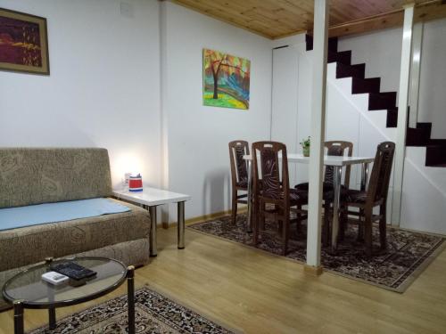 ein Wohnzimmer mit einem Sofa, einem Tisch und Stühlen in der Unterkunft Tiki Apartmen in Belgrad