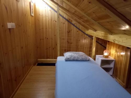 ein Schlafzimmer mit einem Bett in einer Holzhütte in der Unterkunft Tiki Apartmen in Belgrad