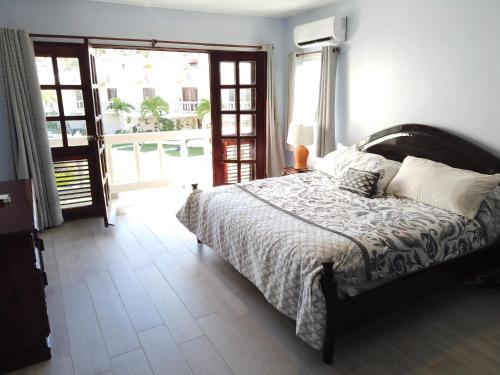 a bedroom with a bed and a large window at Nanny Estates Cabarete kiters Condo C-6 in Cabarete