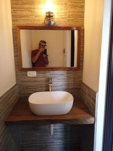 a man taking a picture of a sink in a bathroom at Nanny Estates Cabarete kiters Condo C-6 in Cabarete