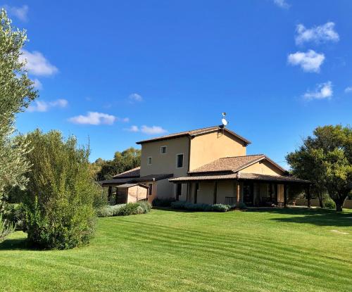 a large house with a large grassy yard at Inghirios Wellness Country Resort in Santa Maria la Palma