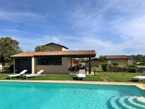 a villa with a swimming pool in front of a house at Inghirios Wellness Country Resort in Santa Maria la Palma